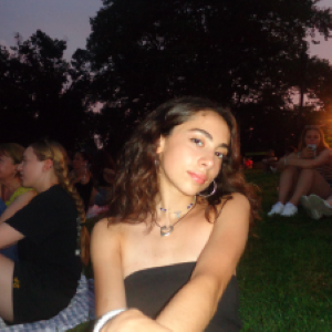 A college student sitting down at a park